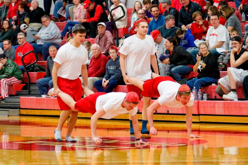 a group of men in red and white shirts on a basketball court