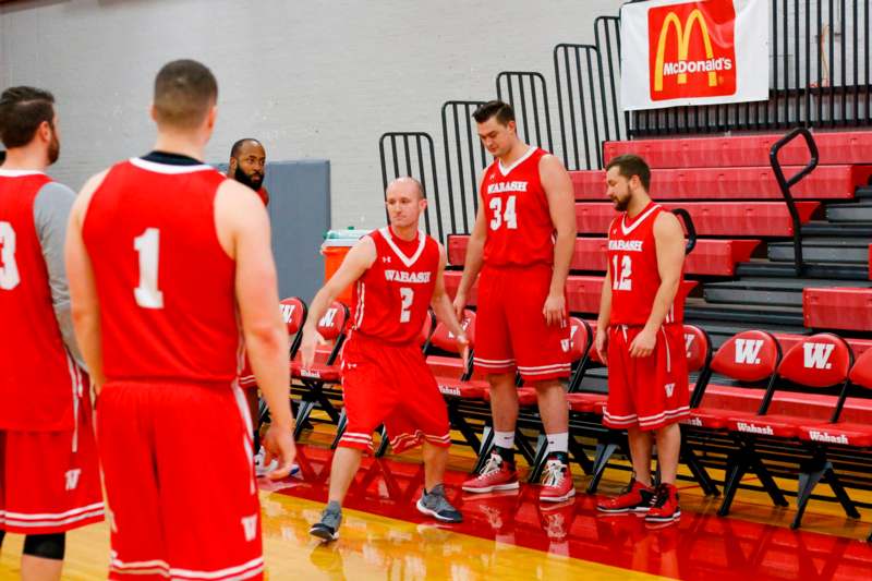 a group of men in red uniforms standing in a gym