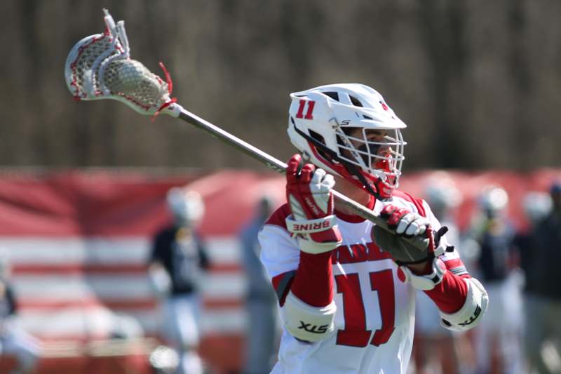 a person wearing a helmet and holding a lacrosse stick