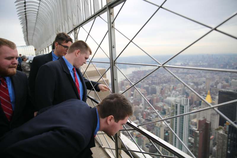 a group of men looking through a metal railing