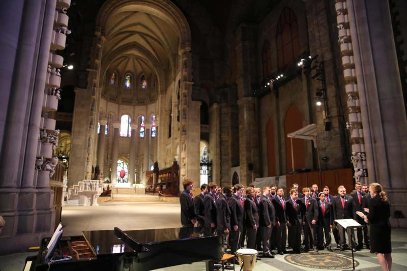a group of people in suits standing in a church
