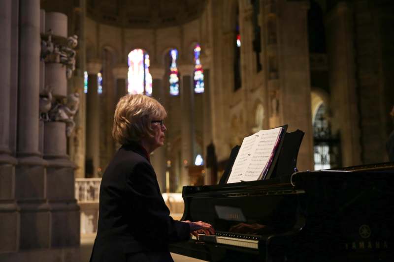 a woman playing a piano in a church