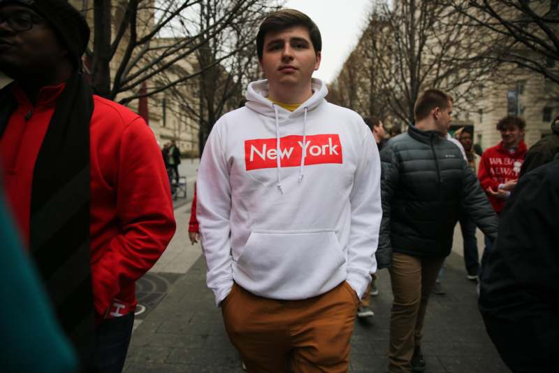 a man in a white sweatshirt with red text