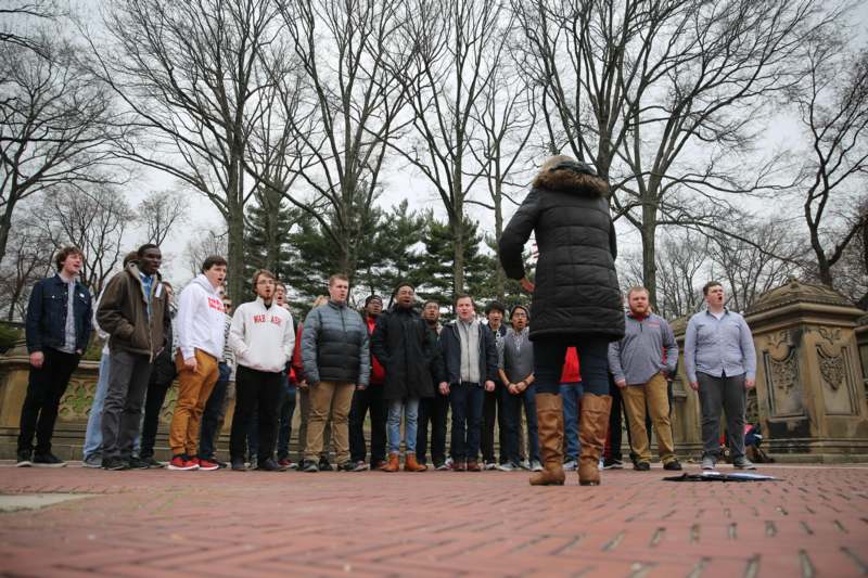 a group of people standing on a brick surface