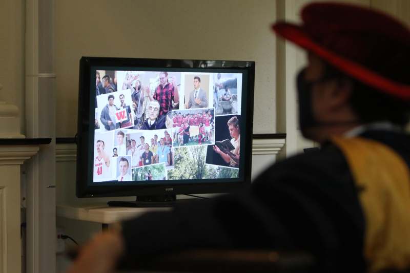 a man in a red hat watching a television