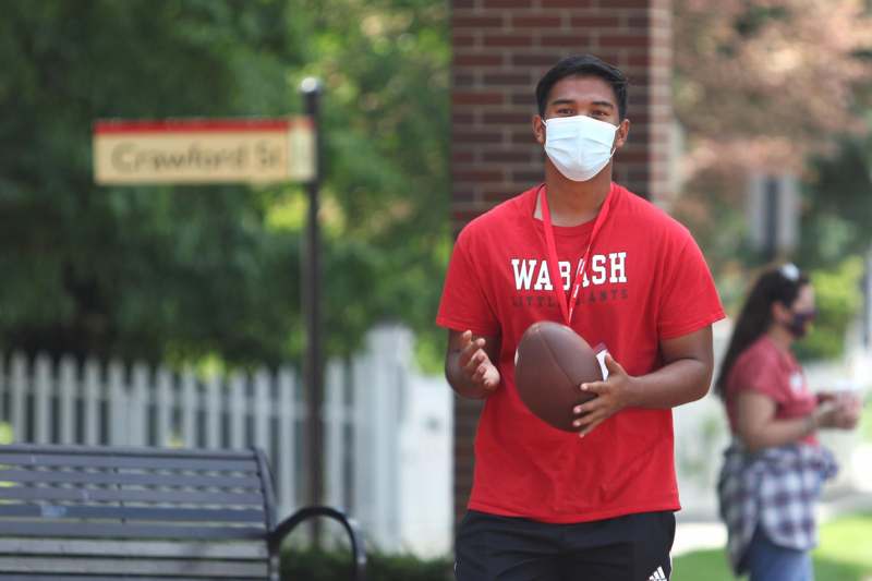a man wearing a face mask holding a football