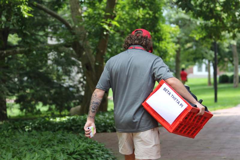 a man carrying a red crate