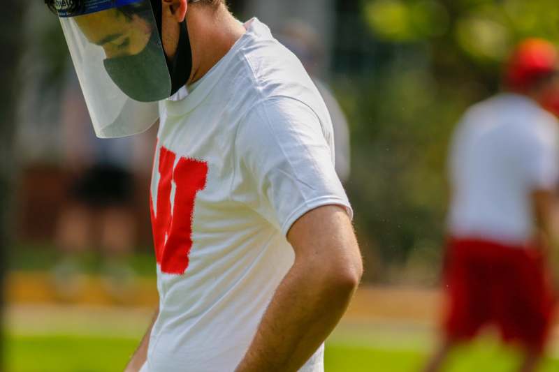 a man wearing a visor and a white shirt