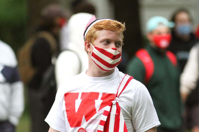 a man wearing a red and white striped face mask