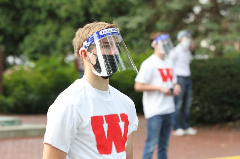 a man wearing a face shield and a white shirt