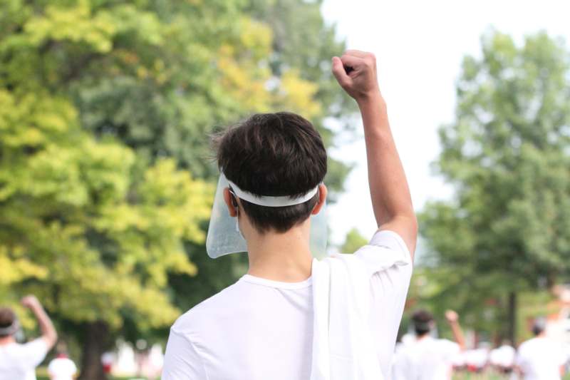 a person with a white visor and a white shirt raising his fist