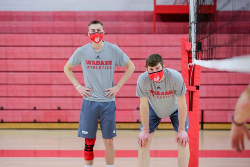 two men wearing face masks in a gym