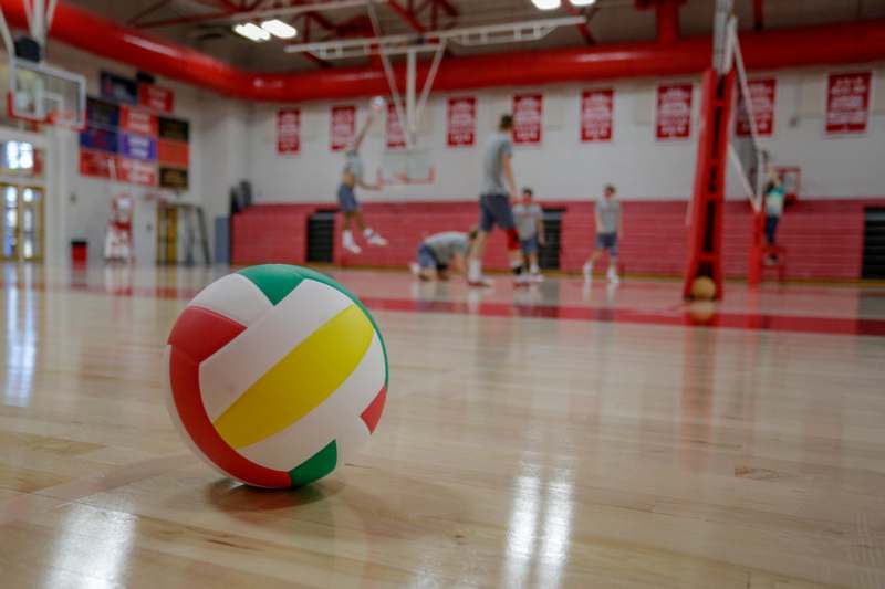 a volleyball on a wooden floor in a gym