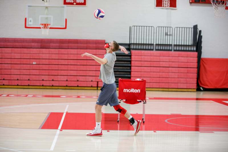 a man in a mask playing volleyball