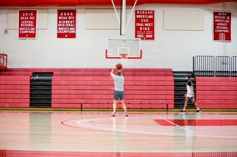 a man shooting a basketball in a gym