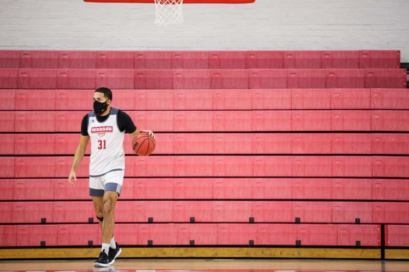 a man wearing a face mask and holding a basketball