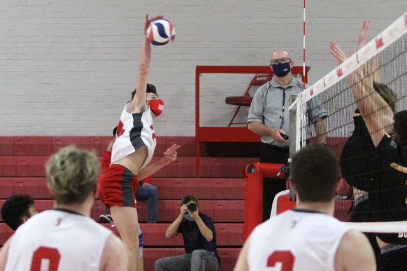a man jumping in the air to block a volleyball