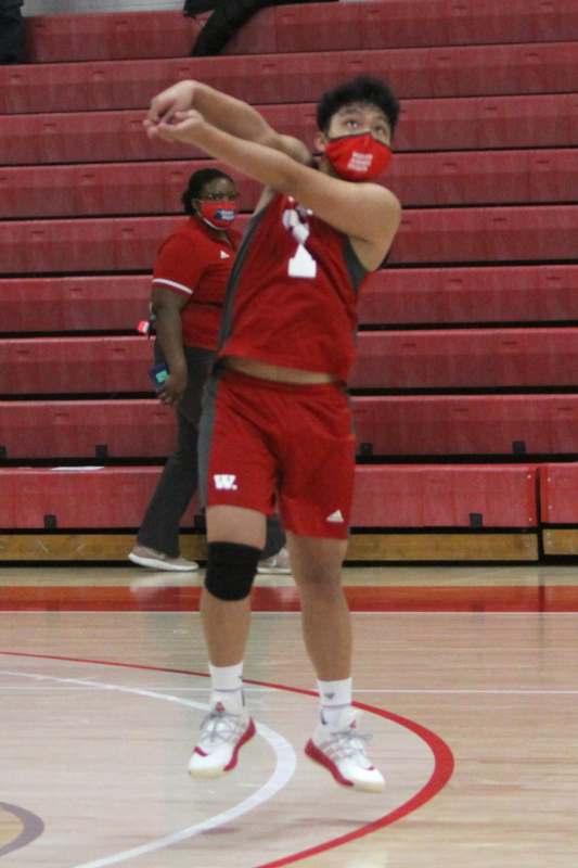 a person in a red uniform playing basketball