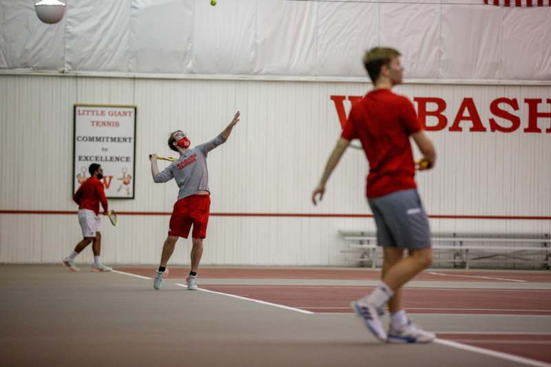 a man in a mask hitting a tennis ball with racket
