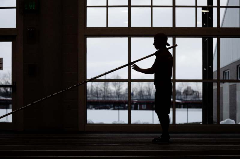 a silhouette of a man holding a pole