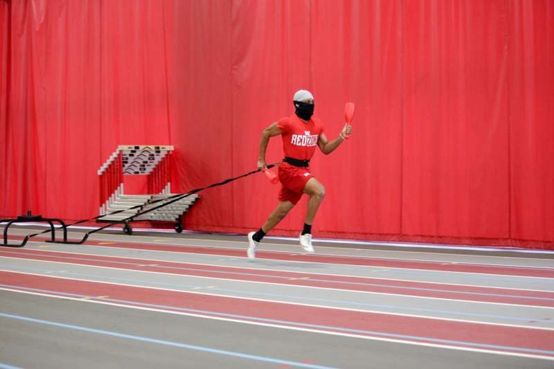 a man running on a track with a leash