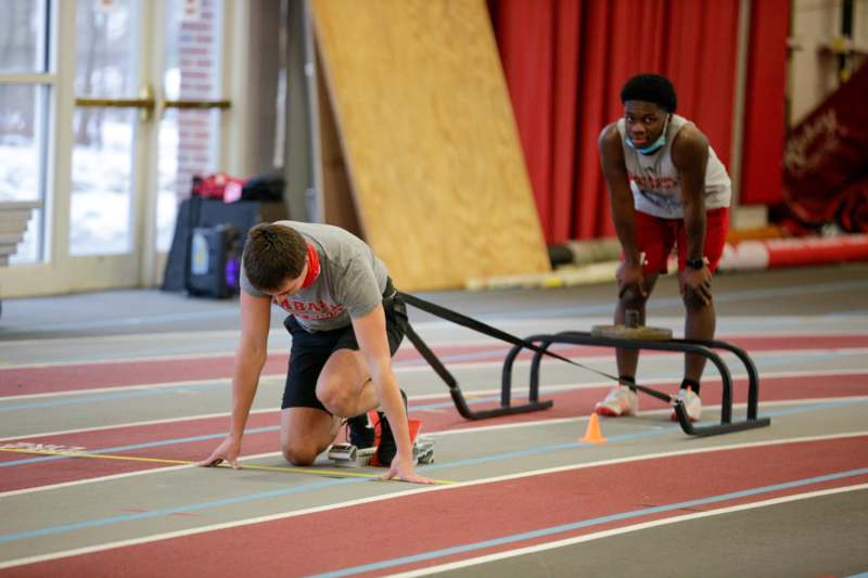 a man on a track with a person on the starting line