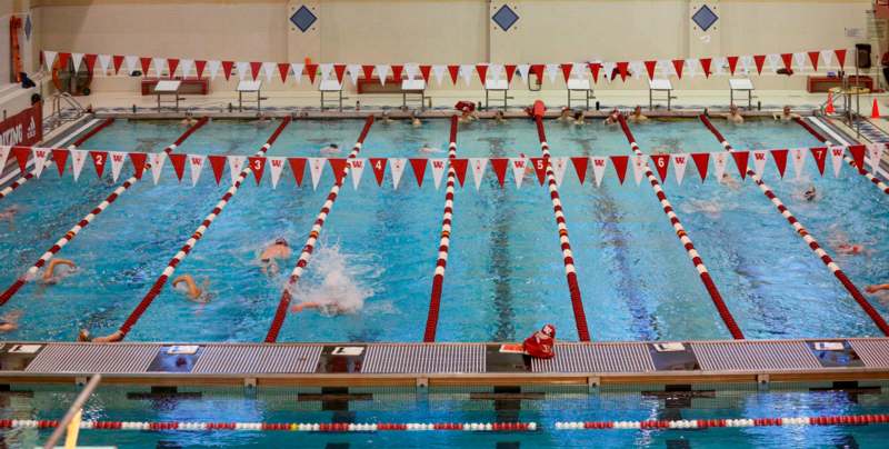 a swimming pool with red and white flags