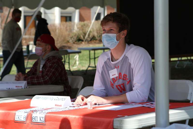 a man wearing a face mask sitting at a table