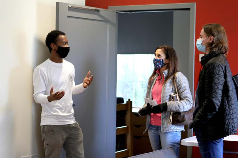 a man wearing face masks talking to a woman