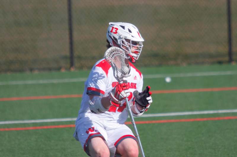 a person in a lacrosse uniform holding a stick