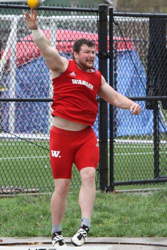 a man in red shorts and a red shirt throwing a frisbee