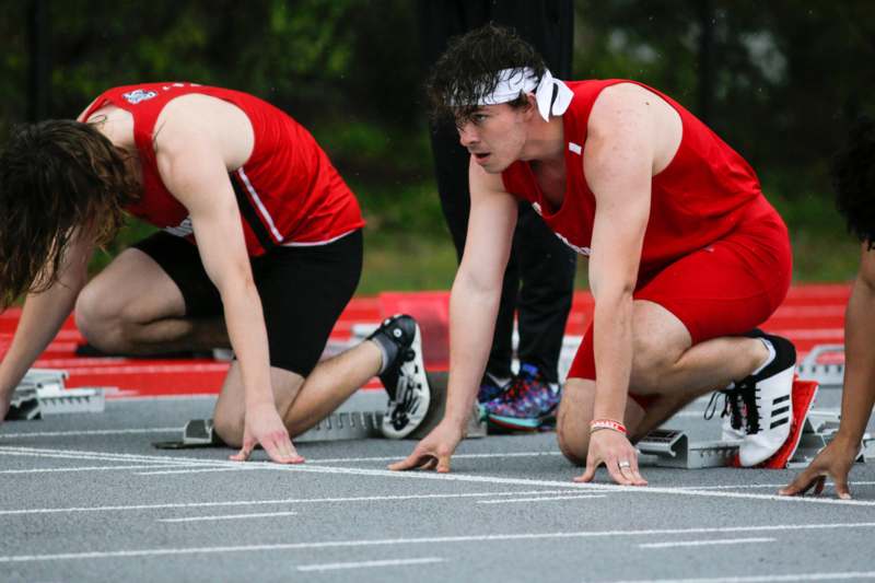 a group of men in red uniforms on a track