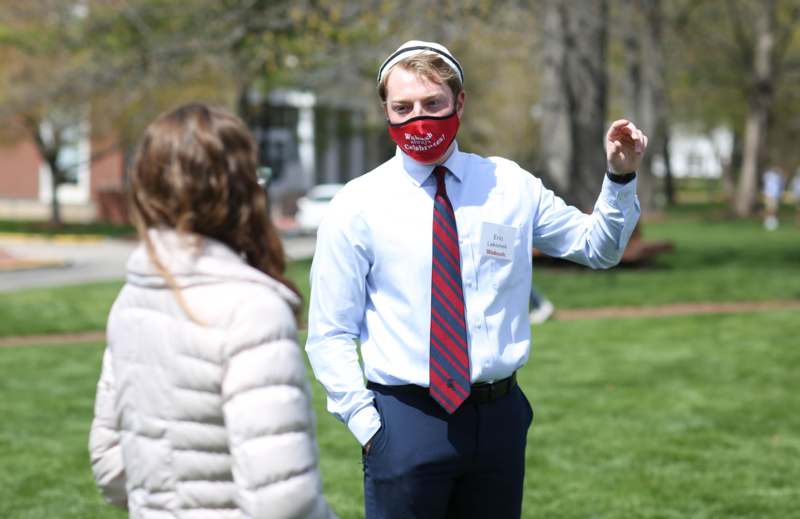 a man wearing a red face mask and standing in a park