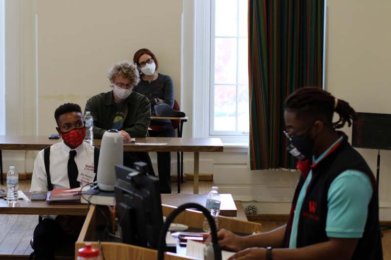 a group of people wearing face masks in a classroom
