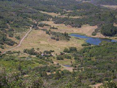 a aerial view of a valley with a pond