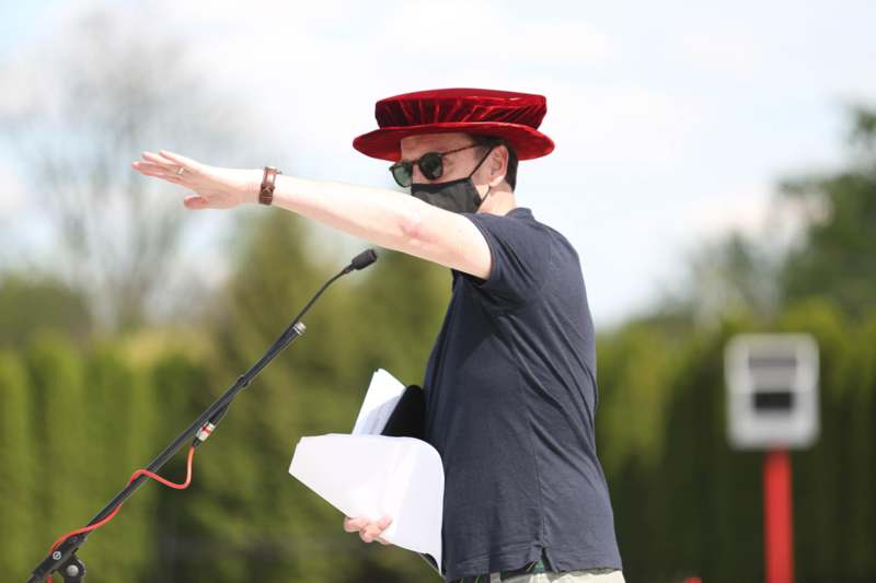 a man wearing a black face mask and a red hat with a microphone