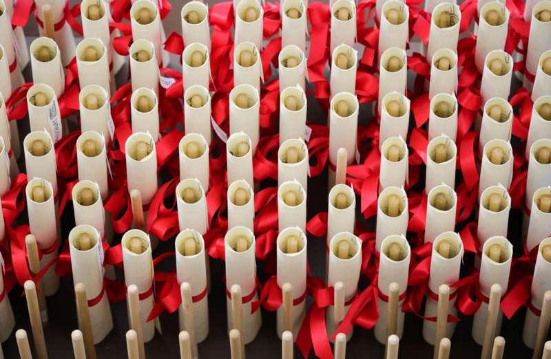 a group of white rolled up paper with red ribbons