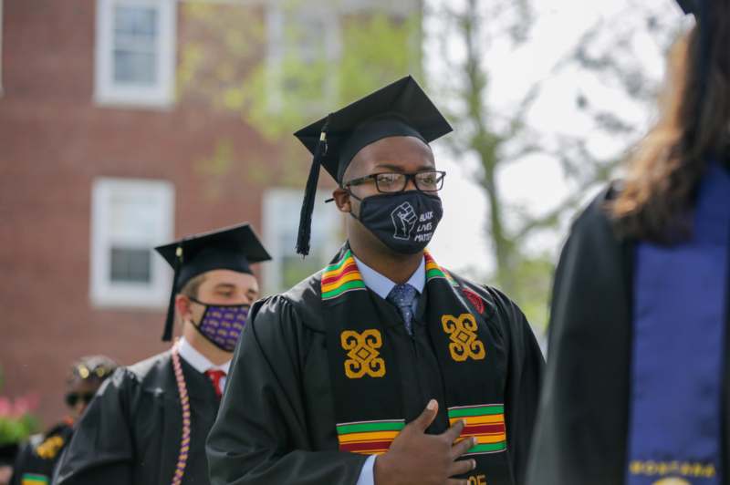 a man wearing a mask and cap and gown