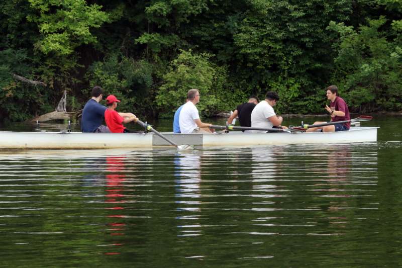 a group of people rowing a boat on a lake