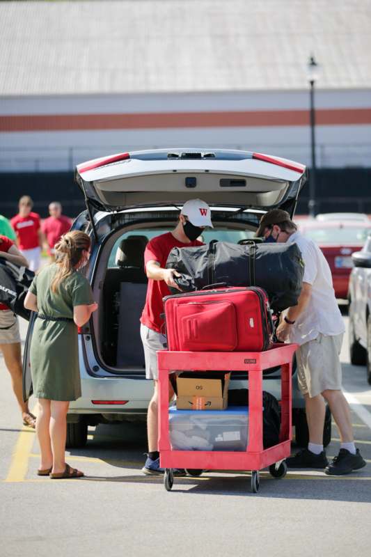 a group of people loading luggage into a car