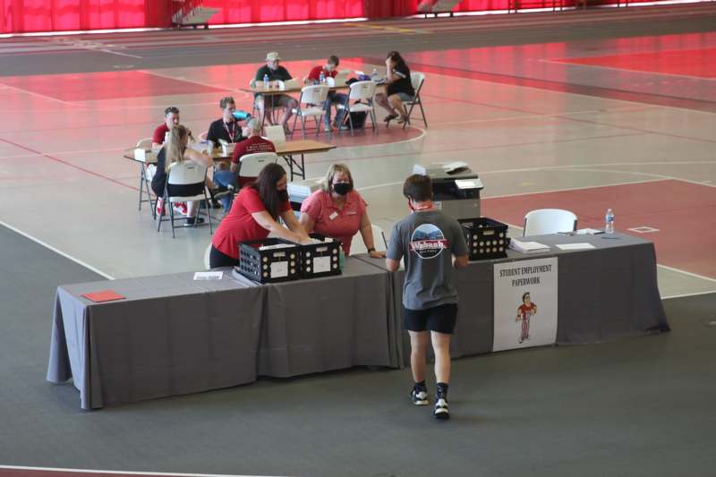 a group of people at tables in a gym