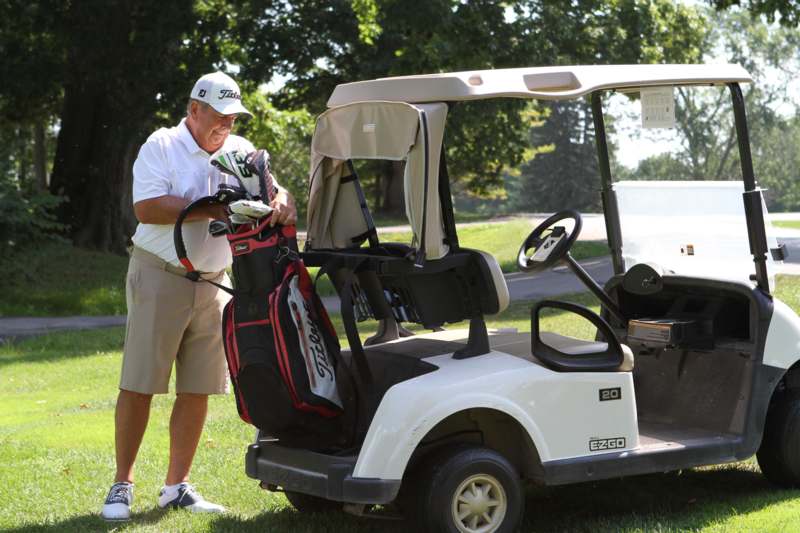 a man standing next to a golf cart
