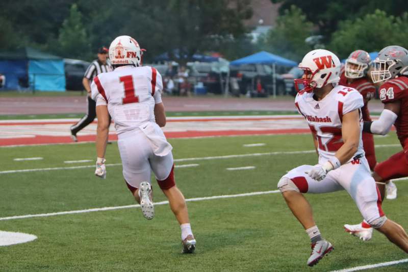 two football players running on a field