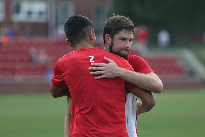two men hugging each other on a field