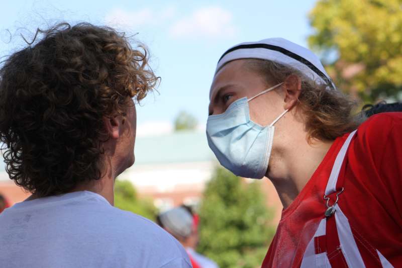 a man wearing a face mask and looking at another man