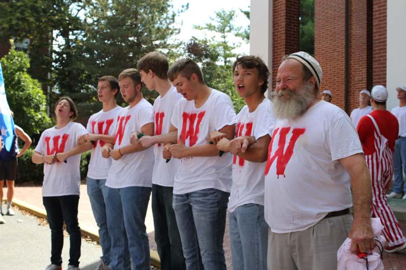 a group of people wearing white t-shirts with red letters