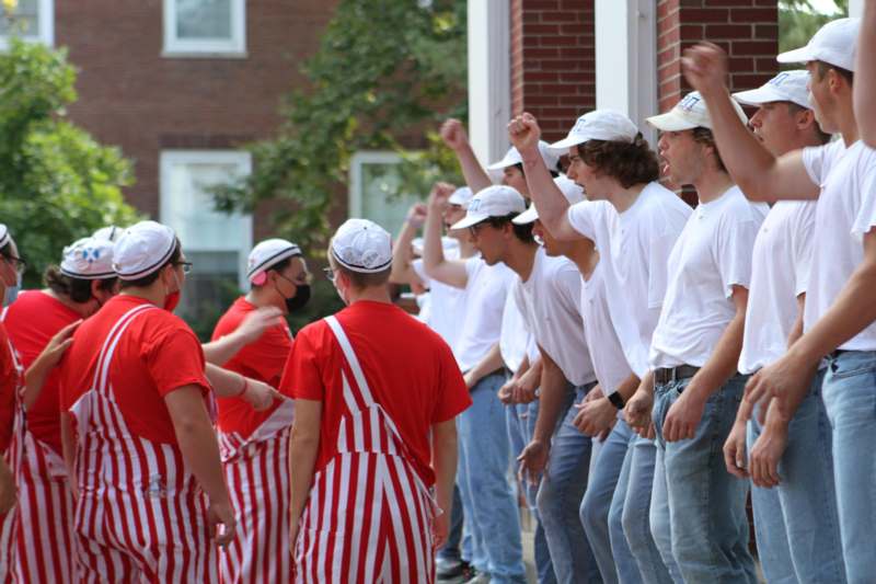 a group of people in white shirts and hats
