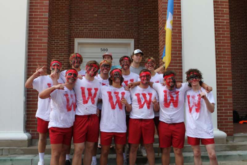 a group of people wearing red and white t-shirts with letters painted on them