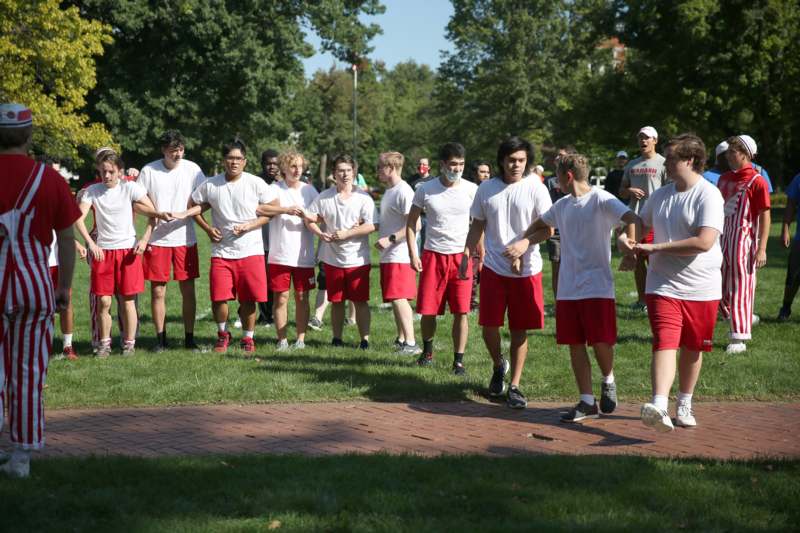 a group of people in white shirts and red shorts