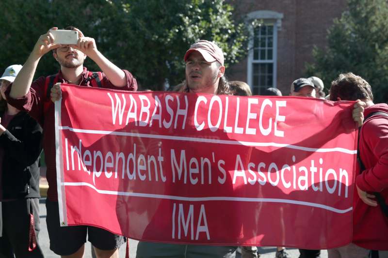 a group of people holding a red banner